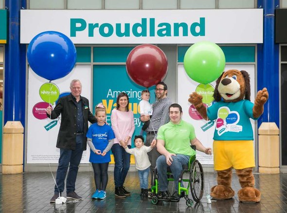 A group of people out side Poundland (labelled Proudland) with balloons
