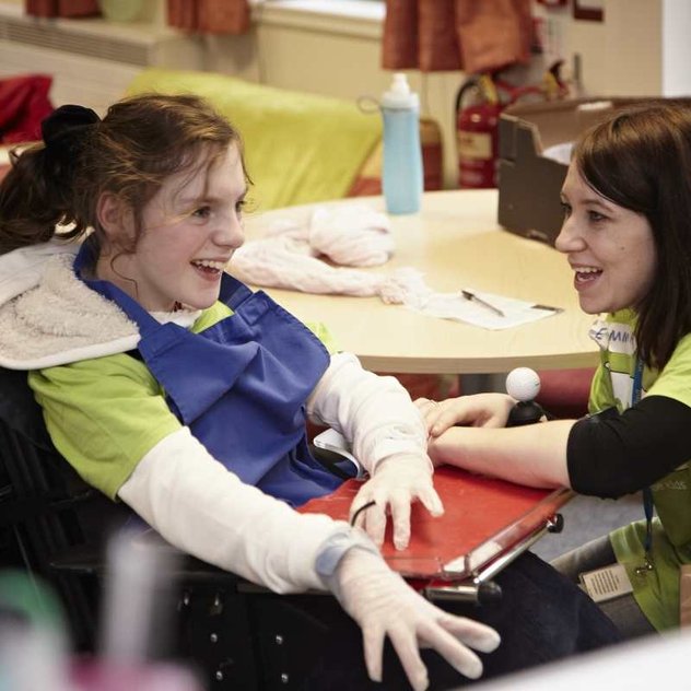 A Whizz Kidz staff member chats to a young wheelchair user
