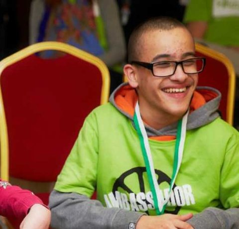 Two young people, sitting and smiling