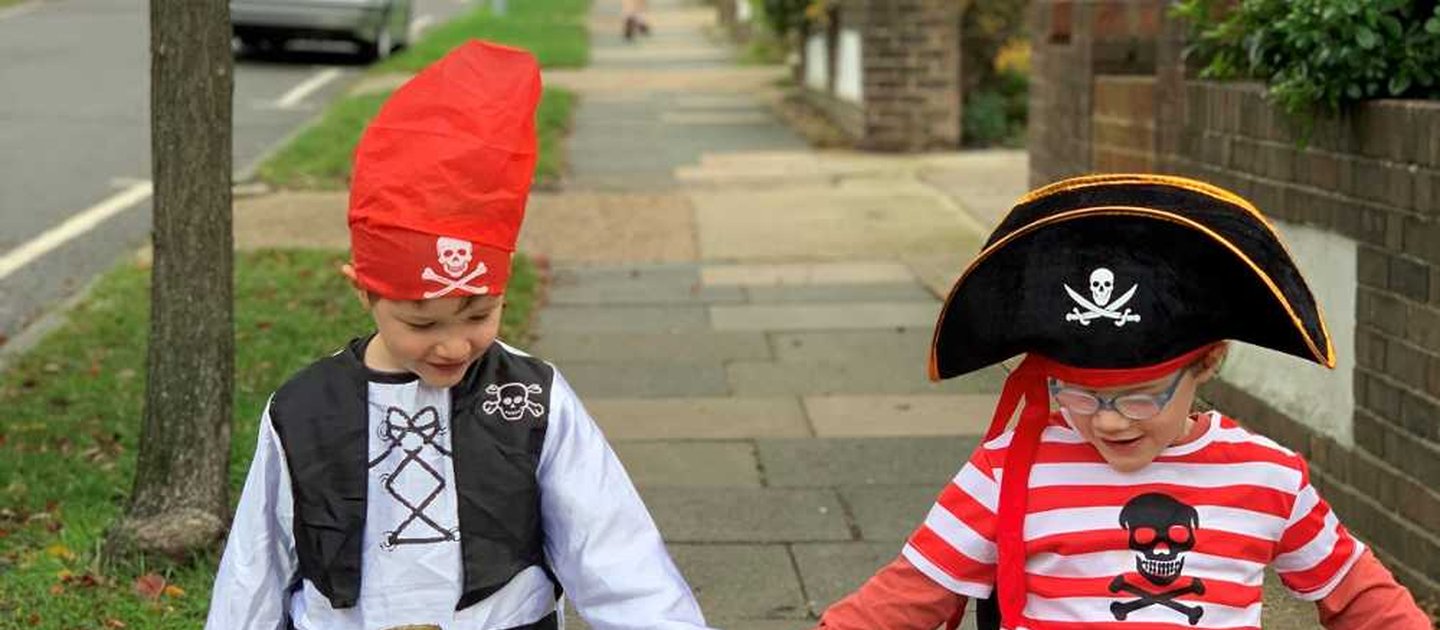 A young wheelchair user and their sibling go along a pavement hand in hand