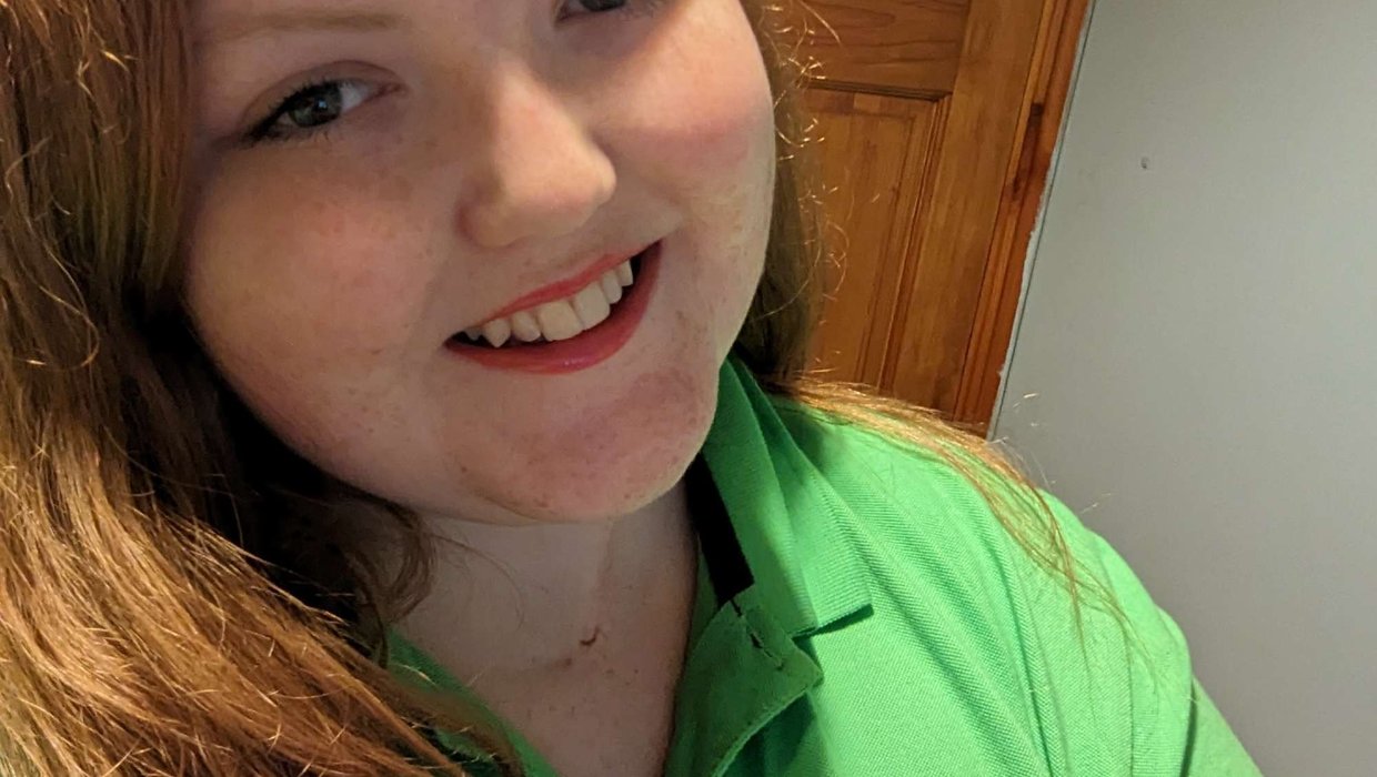 Sophie, our Whizz Kidz volunteer manager smiling wearing a green Whizz Kidz t-shirt